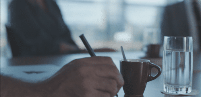 man holding a pen at a meeting