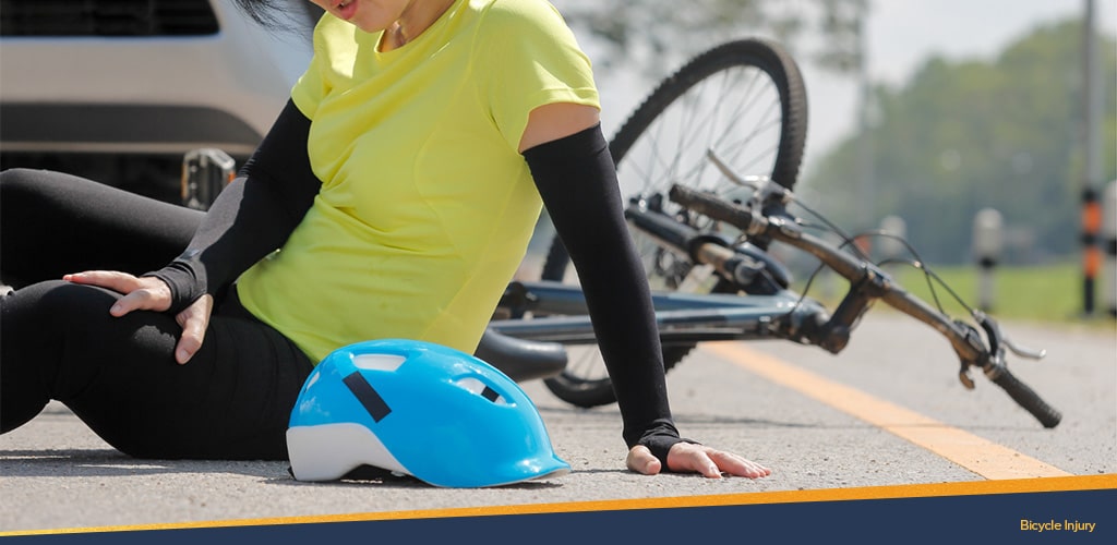 Woman laying hurt in front of a. car with a bicycle, Bicycle injury.