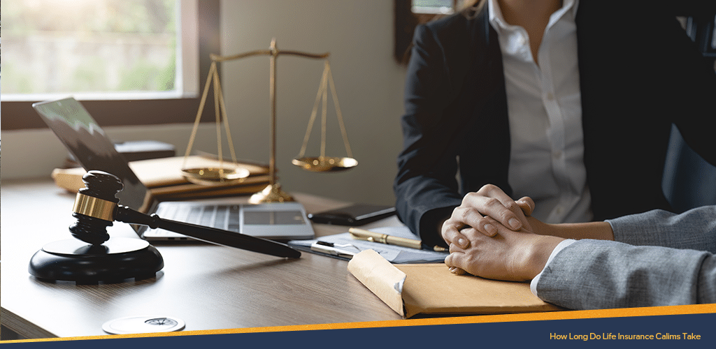 An unseen lawyer reassuring the client by placing his hands on top of the client's hands on a table with a laptop, golden scale, documents and a gavel